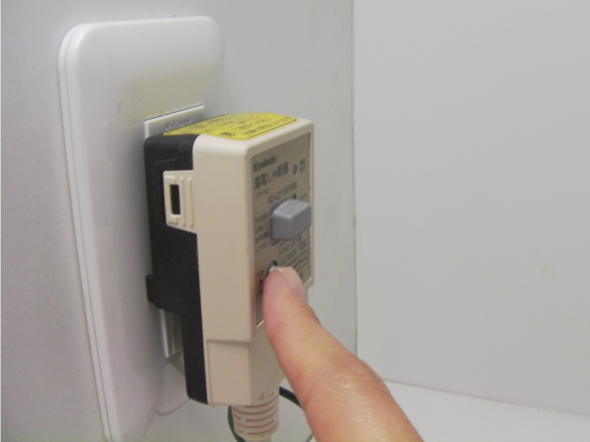 漏電防止プラグのテストボタンを推す